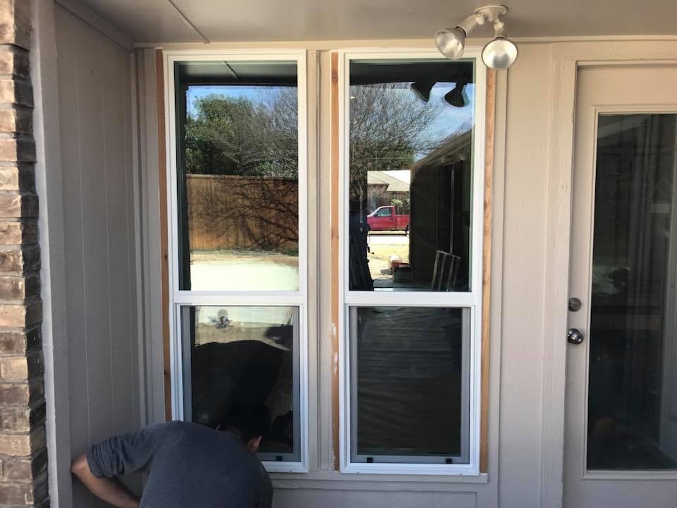 Technician measuring a window opening for replacement installation
