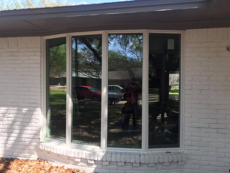 Multiple replacement windows installed on a brick residential home